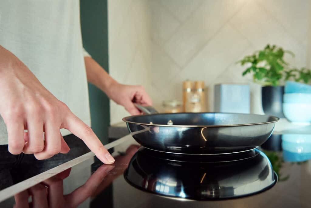 A homebuyer easily adjusts the temperature of the induction cooktop